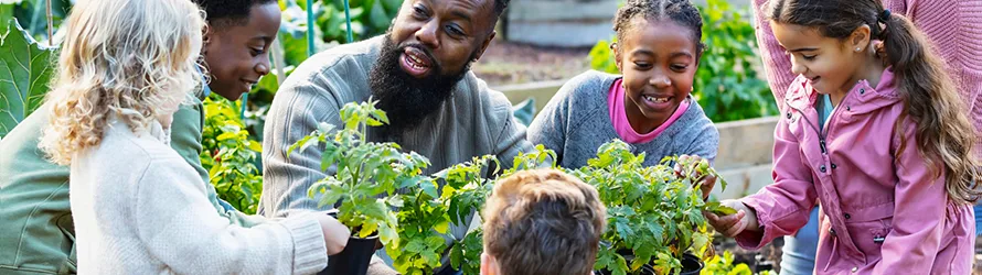 Children and adults working in a community garden