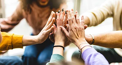 Hands meeting in a team huddle